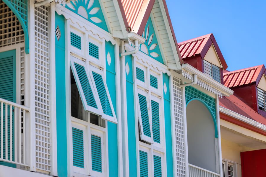 How long does termite treatment last -  Turquoise house with shutters and red roof.