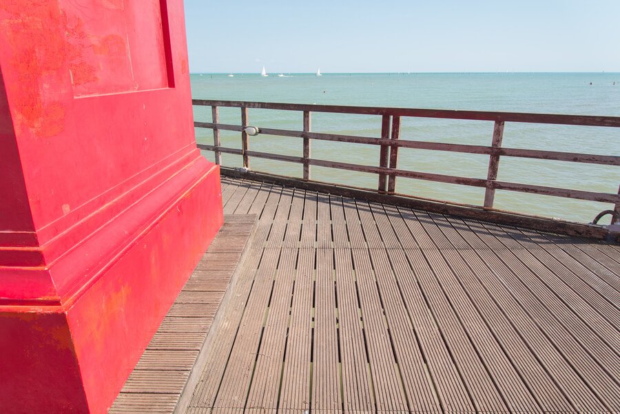 Pest control for ants and termites - Red structure on wooden pier by the sea.
