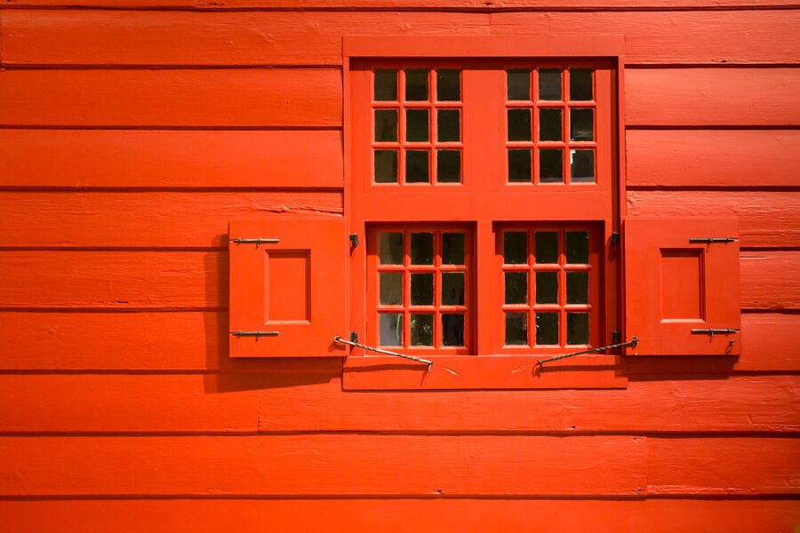 Pest control for ants and termites - Red wooden wall with shuttered window.